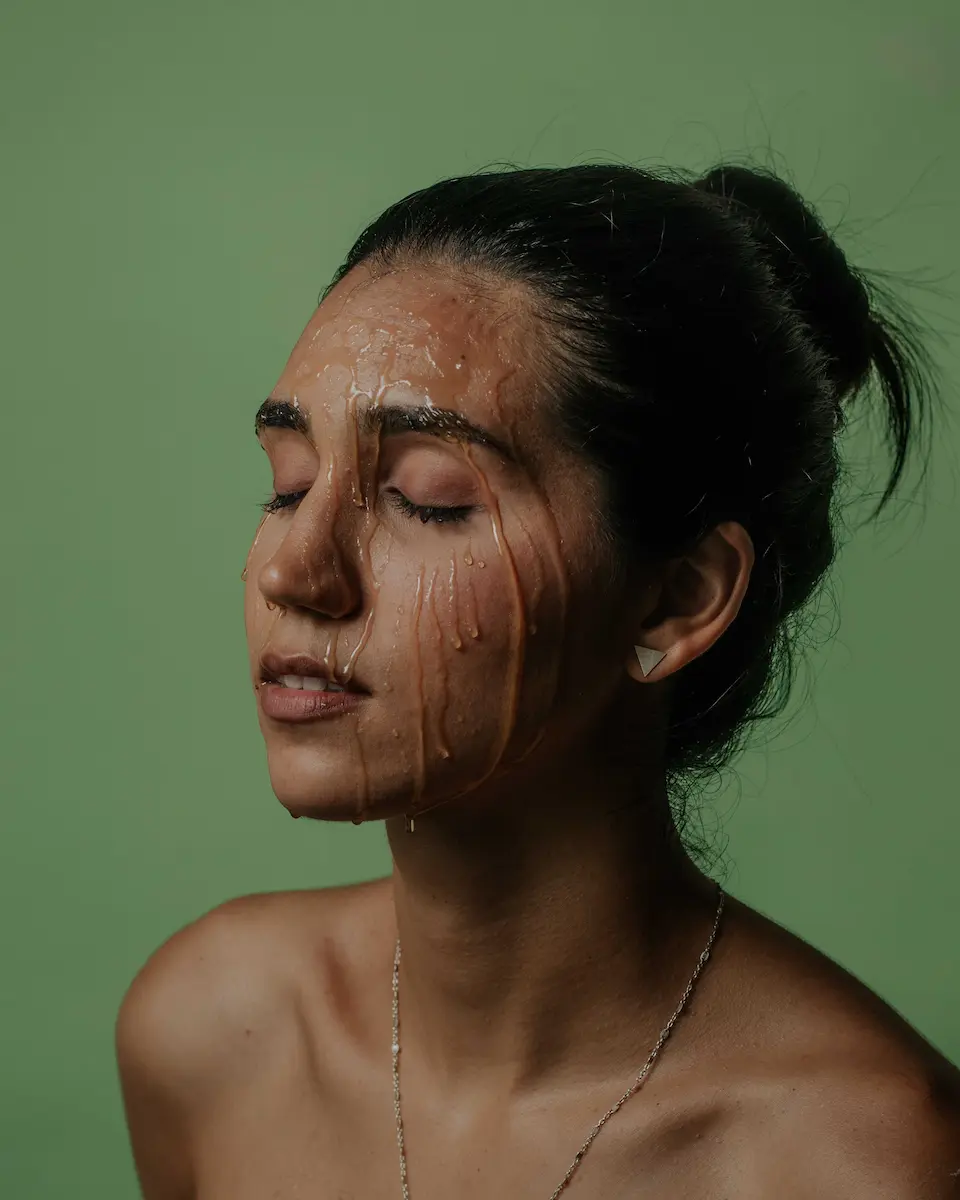 modelo con miel en su rostro