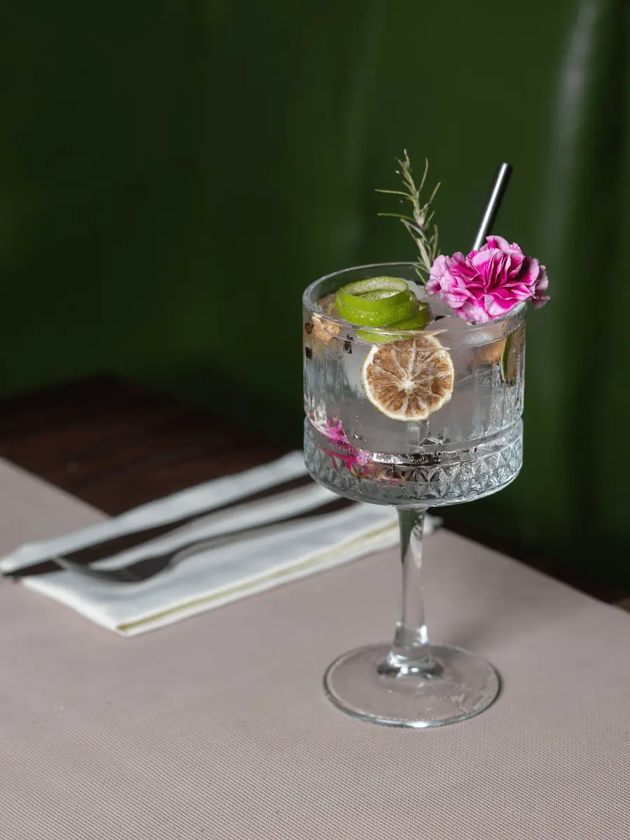 gin tonic en una mesa con una rosa